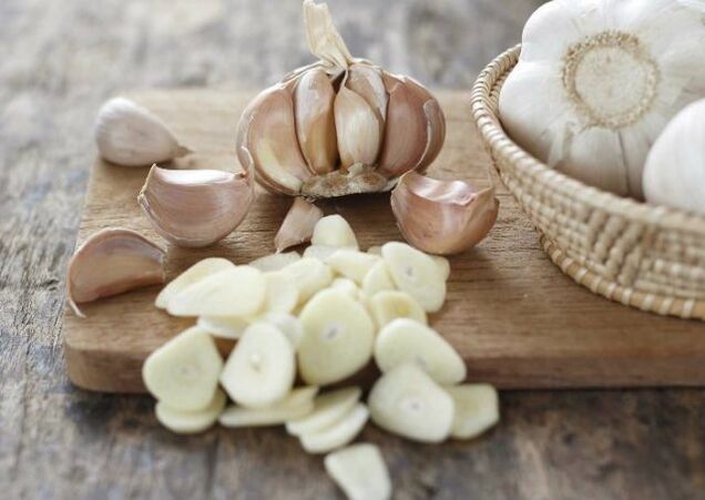 Knoblauch zur Vorbereitung einer wirksamen Massage bei der Behandlung von Arthrose des Kniegelenks.